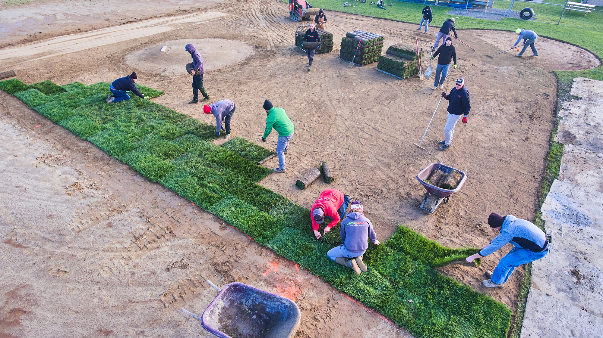 Team volunteering to lay new sod on a local baseball field