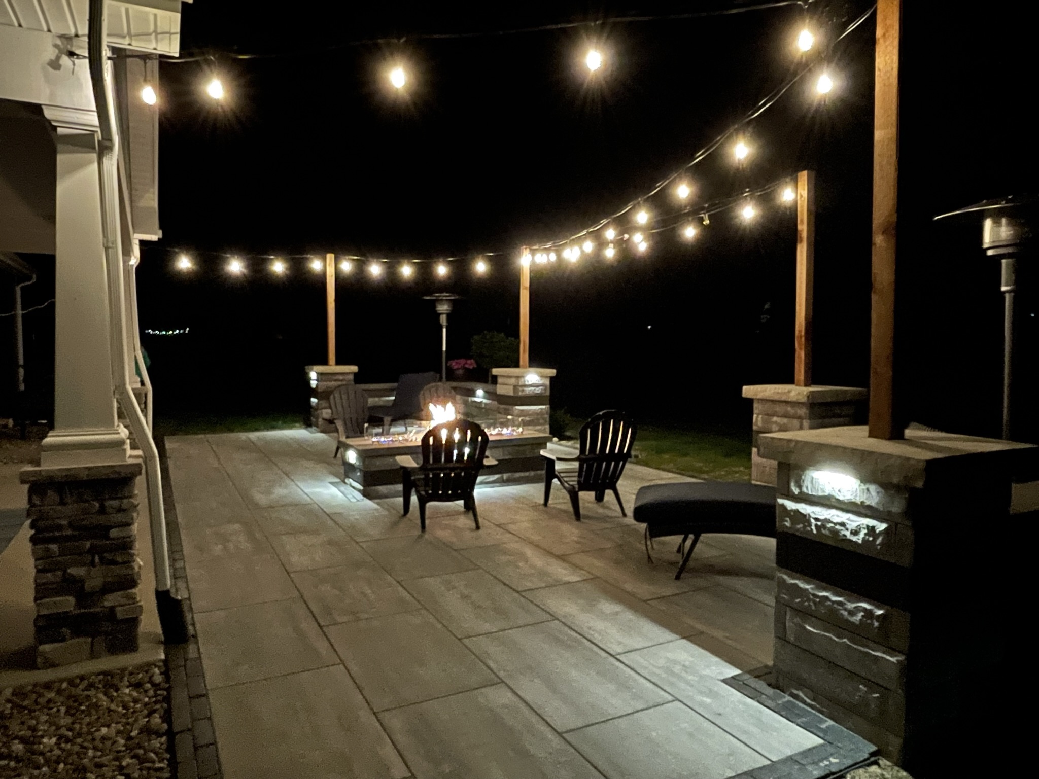 Back patio with firepit and string lights at night