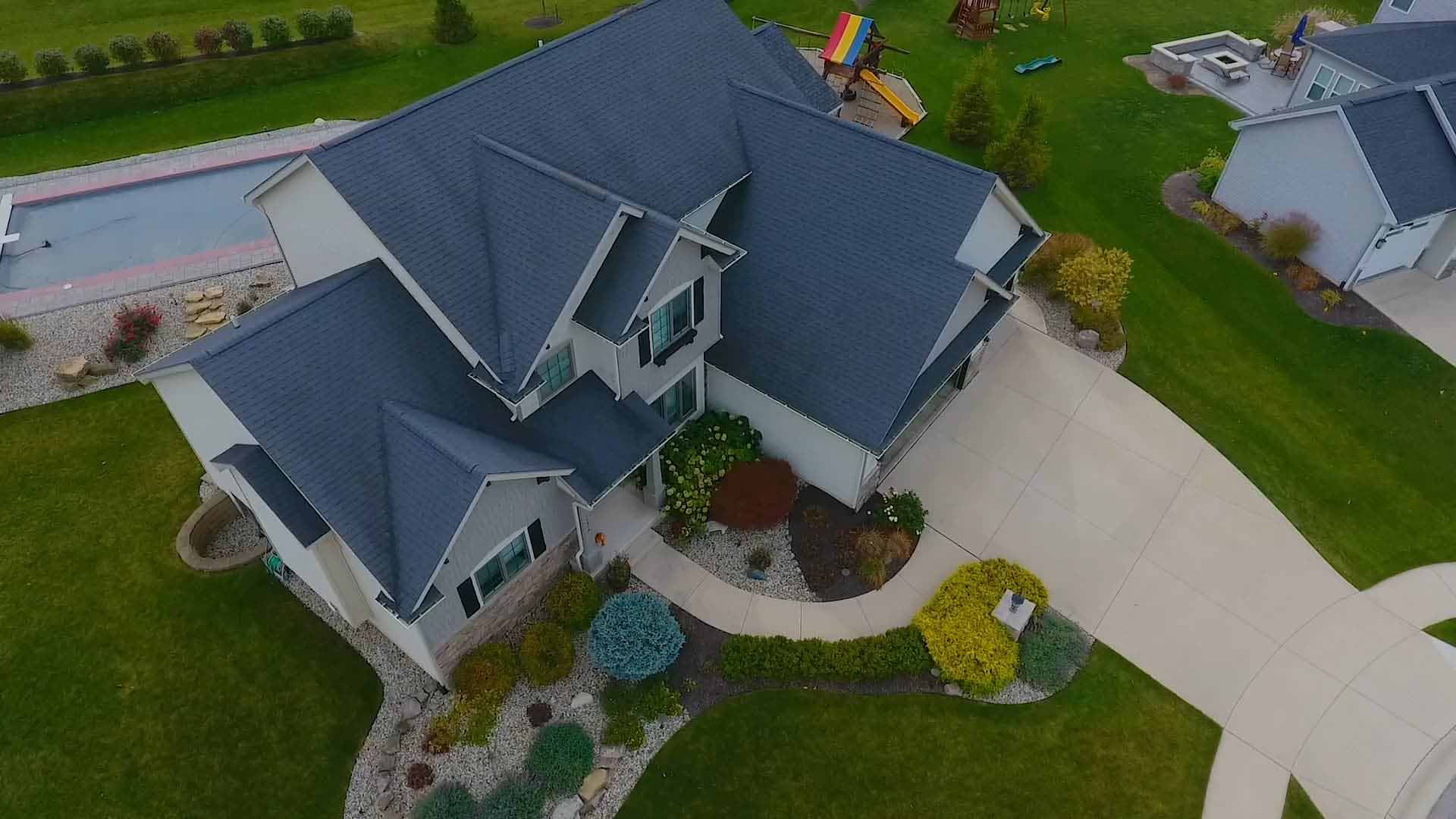 An aerial view of a home and it's manicured lawn.